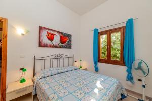 a bedroom with a bed and a window at Centro Residenziale Le Canne in San Teodoro