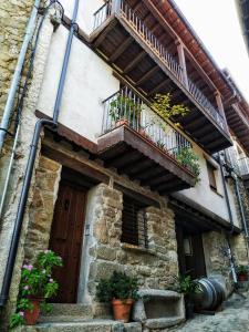 ein Gebäude mit einer Holztür und einem Balkon in der Unterkunft Casa rural La Villa in Miranda del Castañar