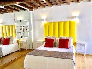 a bedroom with two beds with yellow and red pillows at Palace fontana di trevi home in Rome