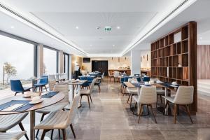 ein Restaurant mit Tischen und Stühlen und Fenstern in der Unterkunft Exe Saldanha in Lissabon