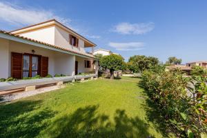 a backyard of a house with a green lawn at Centro Residenziale Le Canne in San Teodoro