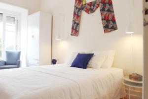 a bedroom with a bed with a cross hanging on the wall at Magnolia Guesthouse in Lisbon