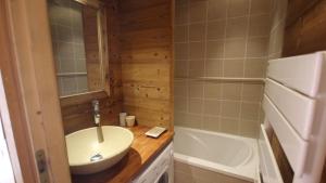a small bathroom with a sink and a tub at Appartement au lac ski aux pieds in Tignes