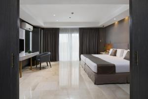 a hotel room with a bed and a desk at City Garden Suites in Manila