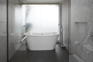 a white bath tub in a bathroom with a shower at City Garden Suites in Manila
