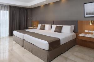 1 dormitorio con 1 cama grande en una habitación en City Garden Suites, en Manila