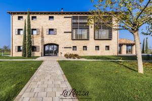a large brick building with a tree in front of it at Agriturismo La Razza in Reggio Emilia
