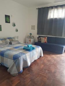 ein Schlafzimmer mit einem Bett und einem Sofa darin in der Unterkunft Cantinho Suico Aluguel de Temporada in Nova Friburgo