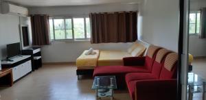 a bedroom with a bed and a red couch at New Room in Nonthaburi