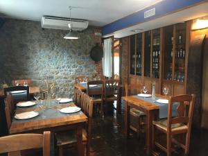 a restaurant with wooden tables and chairs and a brick wall at Posada La Llosa de Somo in Somo