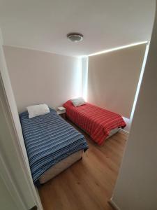 a small room with two beds in it at Departamento en Lomas de Papudo V in Papudo