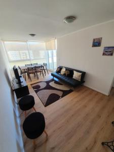 a living room with a couch and a table at Departamento en Lomas de Papudo V in Papudo +22 photos