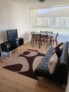 a living room with a couch and a table with chairs at Departamento en Lomas de Papudo V in Papudo