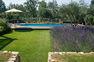 トゥレット・シュル・ルーにあるLa Lavandeのプールと紫色の花が咲く庭園のある庭