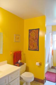 a yellow bathroom with a toilet and a sink at Yellow Door Bed and Breakfast in Crystal Beach
