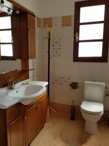 a bathroom with a sink and a toilet and a window at Charming Country House with View in Episkopí- Rethimno