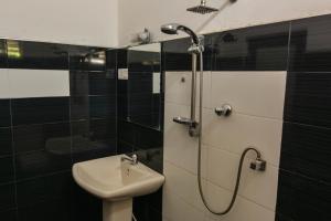 La salle de bains est pourvue d'un lavabo et d'une douche. dans l'établissement Mallika Resort, à Mirissa
