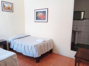 a small room with a bed and a sink at Mango Hostel B&B in Arequipa