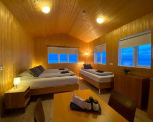 a bedroom with two beds and a table and a table sidx sidx sidx at Beindalsholt in Hella