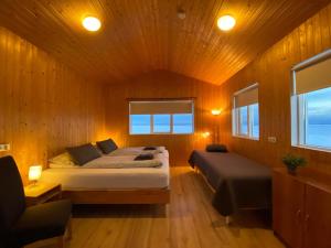 1 dormitorio con 2 camas en una habitación de madera en Beindalsholt, en Hella