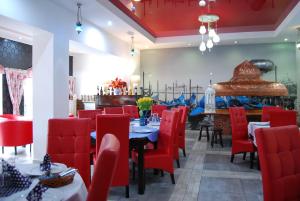 ein Restaurant mit roten Stühlen und Tischen in einem Raum in der Unterkunft Amigo Hotel in Sulejówek