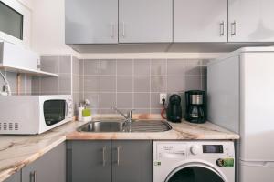 a kitchen with a sink and a washing machine at Atlantis Flat. Relaxing Moments in Machico
