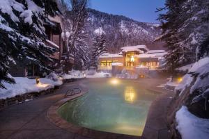 a swimming pool in front of a house in the snow at The Gant in Aspen