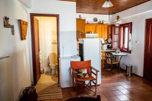 Il comprend une cuisine équipée d'un réfrigérateur, d'une table et de chaises. dans l'établissement Agioklima Traditional Cretan House, à Petrokefalo