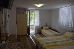 a bedroom with two beds and a window at Стаи за гости "Нина" in Velingrad