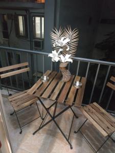 einen Balkon mit zwei Bänken und einer Vase aus Blumen in der Unterkunft G M 1 ROOMS KENTRO in the heart of the city in Larisa