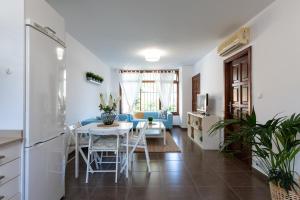 una cucina e un soggiorno con tavolo e sedie di Bungalow next to the Beach a Puerto Rico de Gran Canaria