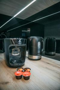 a coffee maker and three cups on a wooden counter at Vistula Terraces Apartment in Kraków