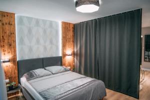 een slaapkamer met een bed met een groen gordijn bij Vistula Terraces Apartment in Krakau