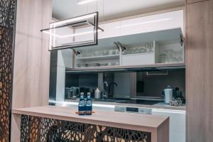 a kitchen with a counter with bottles on it at Vistula Terraces Apartment in Kraków