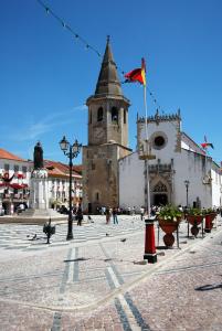 a building with a tower with a flag on it at São Gião House 4 in Tomar