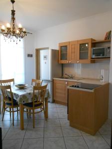 a kitchen with a table and chairs and a kitchen with a refrigerator at Beau 3 pieces proche centre in Menton +4 photos