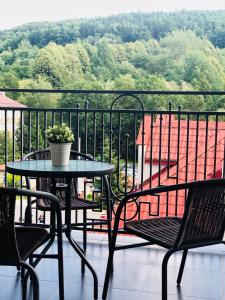 a table and chairs on a balcony with a view at Apartament przy Deptaku in Ustrzyki Dolne
