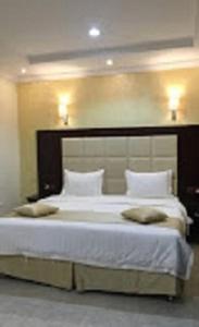 a bedroom with a large white bed with two pillows at Aseel Furnished Apartments in Jeddah