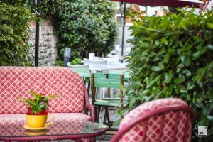 a patio with chairs and a table with a plant at Hotel Alessandro Della Spina in Pisa