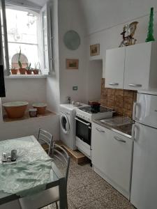 a kitchen with a stove and a white refrigerator at Casa Vacanze Gerardo in Mottola
