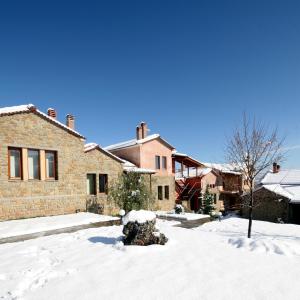 una casa con neve per terra nel cortile di Amadryades Boutique Hotel ad Alatópetra