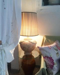 una lampada seduta su un tavolo di vetro accanto a un divano di Casa Vacanze Gerardo a Mottola