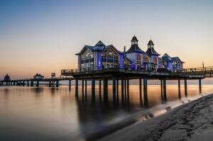 ein Haus auf einem Pier auf dem Wasser in der Unterkunft Kapitänshaus Sellin mit Sauna und Kamin in Ostseebad Sellin