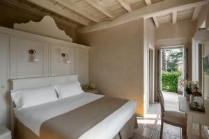 a bedroom with a bed and a table and a window at Hotel Palazzo Novello in Montichiari