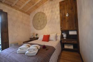 a bedroom with a bed with towels on it at El Balcon de Justina - Sierra de Gata in Torre de Don Miguel