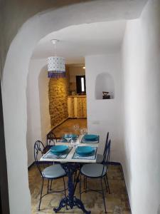 un comedor con una mesa con sillas y una lámpara de araña en El escondite de Martina, Casa Rural Romántica, en Setenil