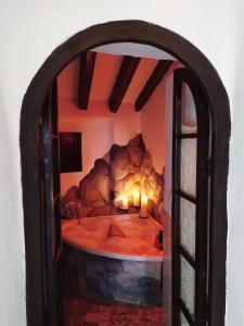 Una habitación con una cama con velas. en El escondite de Martina, Casa Rural Romántica, en Setenil