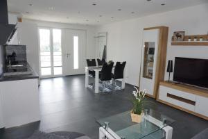 a living room with a table and chairs and a television at Ferienwohnung Schauinsland in Neuenbürg