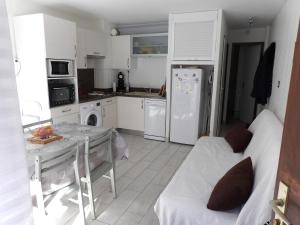 a kitchen with a table and a white refrigerator at Hameau des Thermes - appartement rez de chaussée in Saint-Lary-Soulan