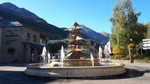 a fountain with a christmas tree in front of a building at Hameau des Thermes - appartement rez de chaussée in Saint-Lary-Soulan